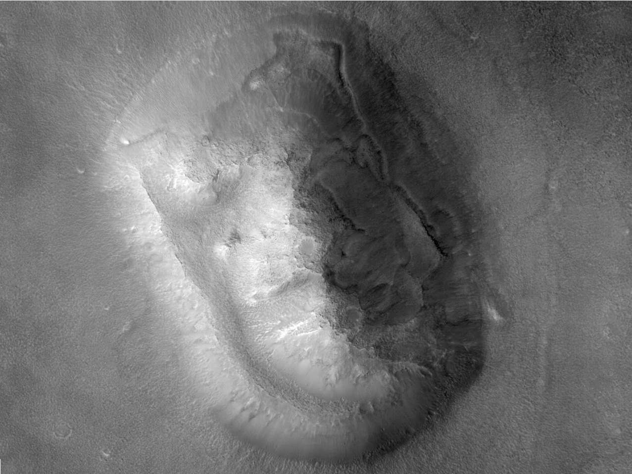 High-resolution HiRISE photo of the Face on Mars mesa showing eroded slopes, boulders and debris, with no face visible
